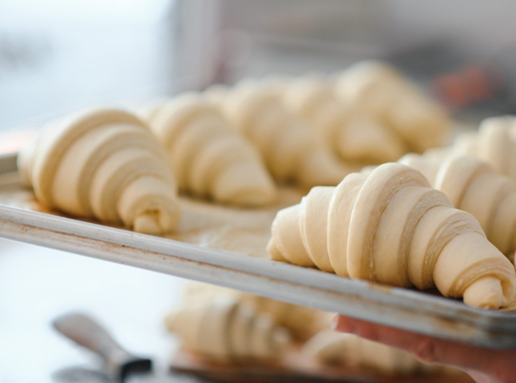 termoregulation: Raw croissants on a baking tray, prepared for baking.